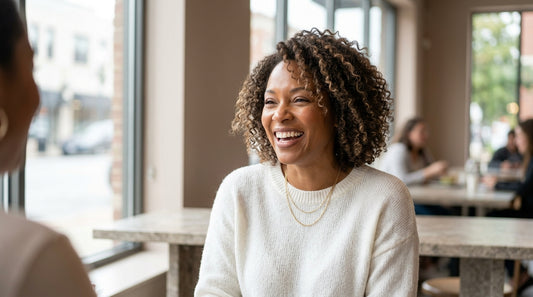 Woman with long honey-blonde wavy wig laughing outdoors — capturing everyday wig lifestyle in a candid photo moment.